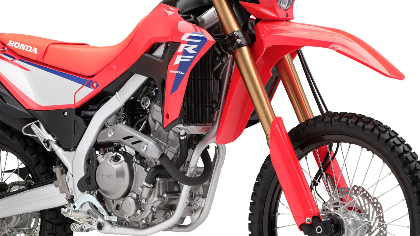 Red Honda CRF300L ridden on a paved mountain road