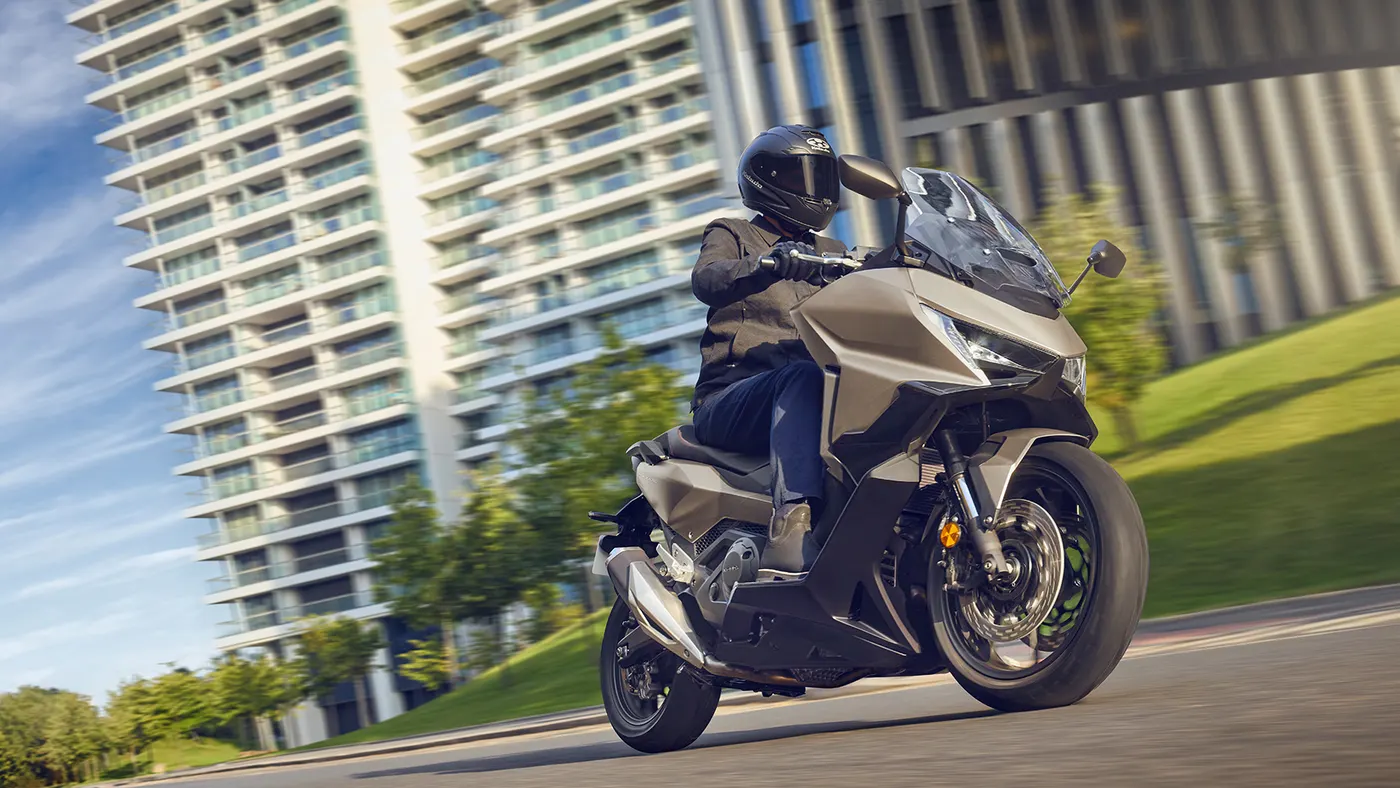 Honda Forza 750 with a rider on a city road