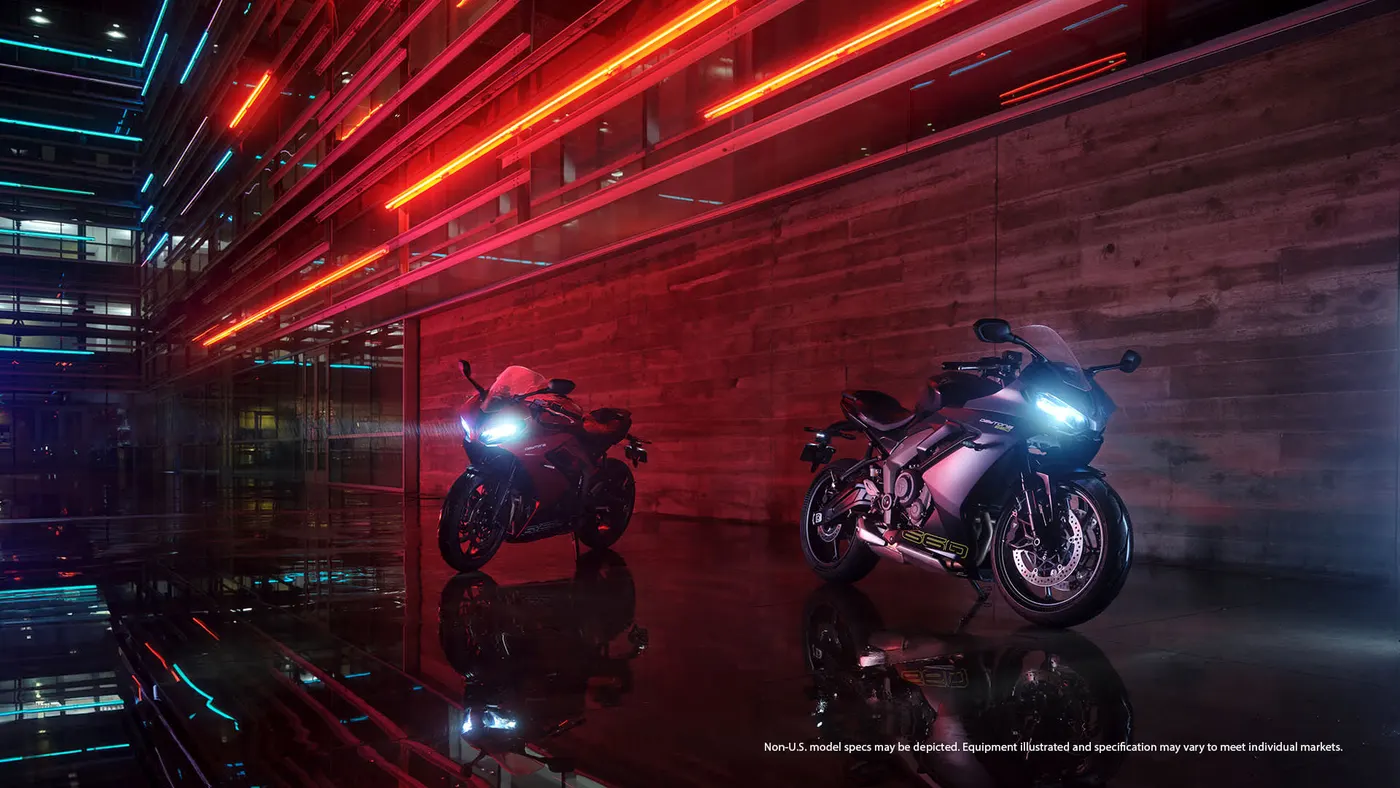 Two Triumph Daytona 660 motorcycles in a dramatic studio scene