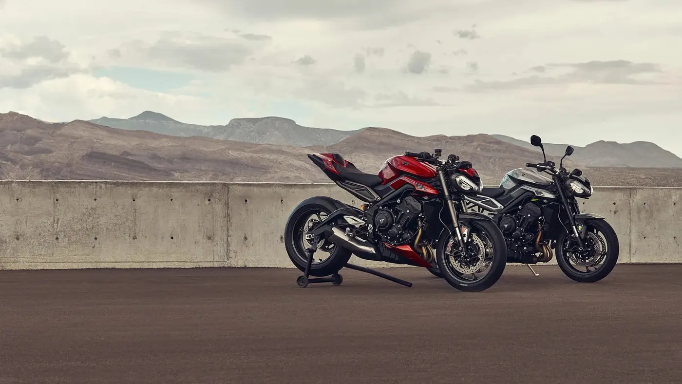 Red and grey Triumph Street Triple 765 motorcycles in a mountain studio scene