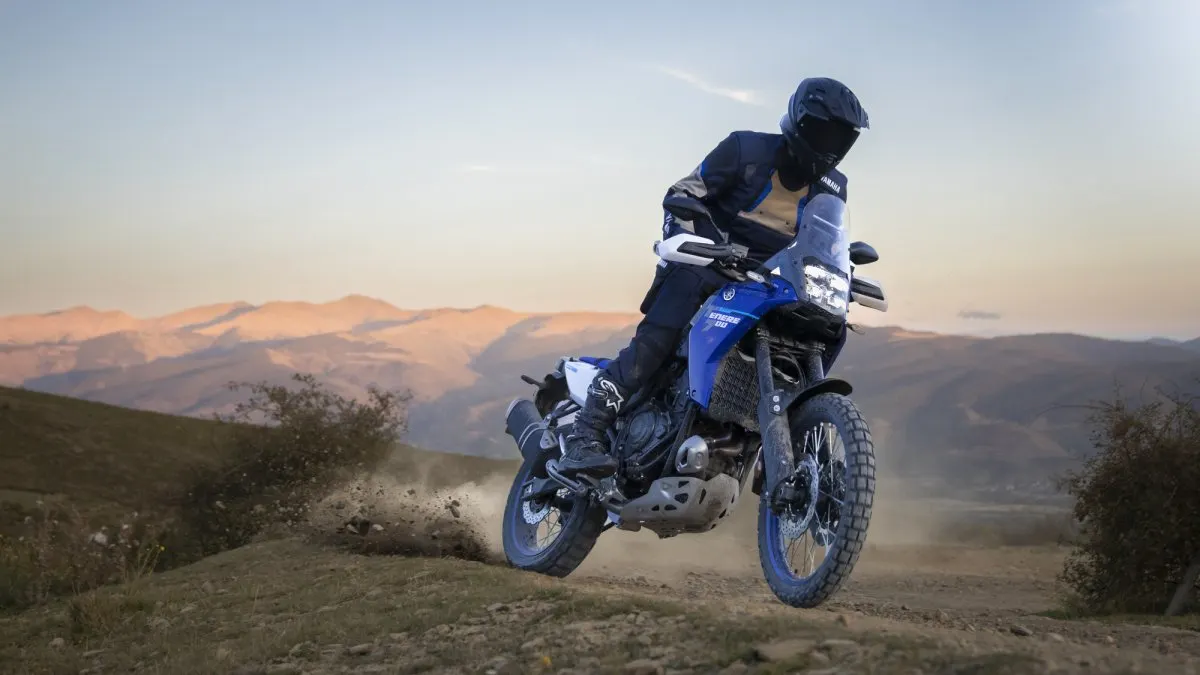 Blue and white Yamaha Ténéré 700 riding on a dusty mountain track